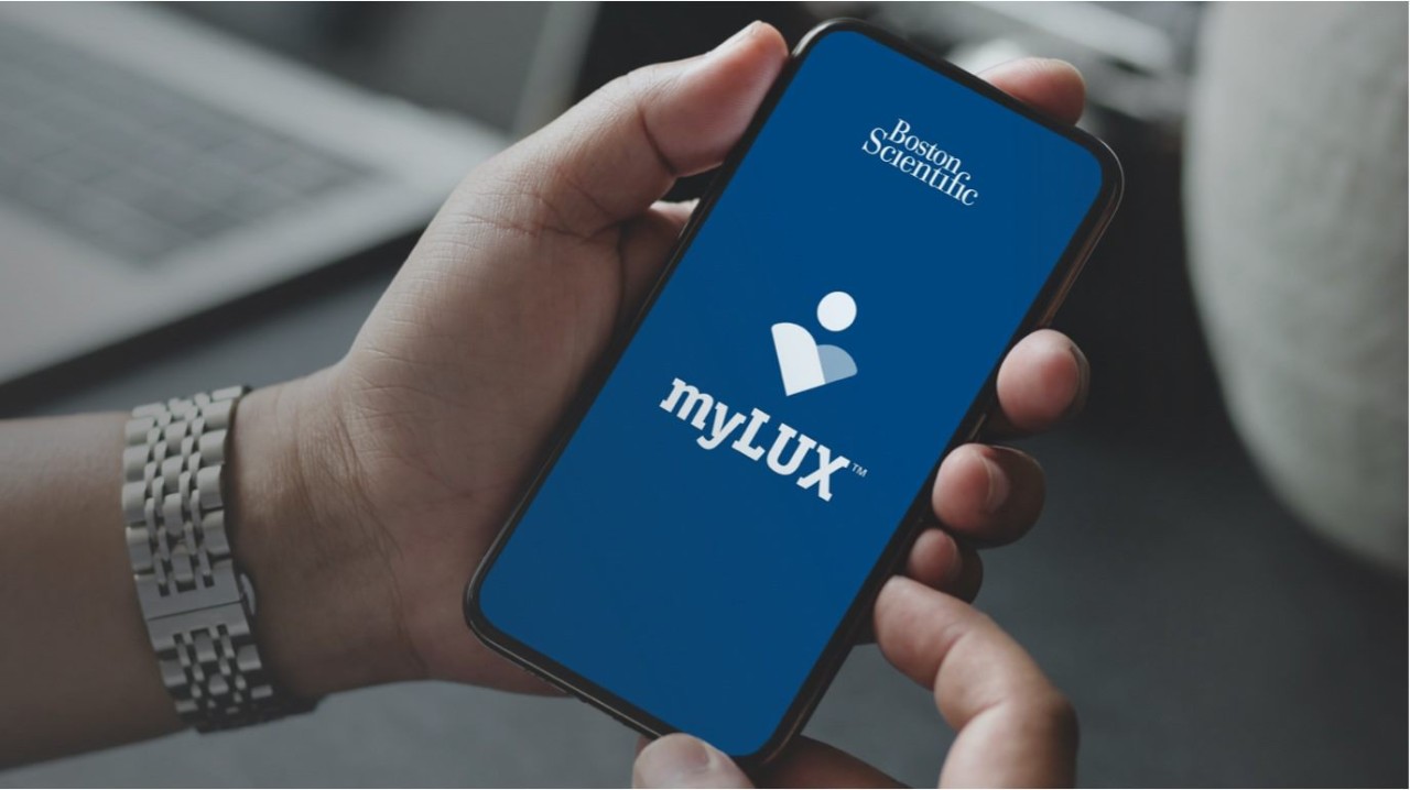Hand with watch holding mobile device showing myLUX app
