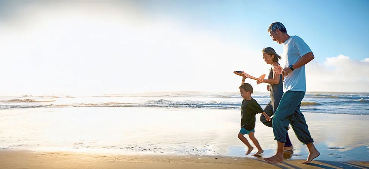 Family of three member running on beach and enjoying