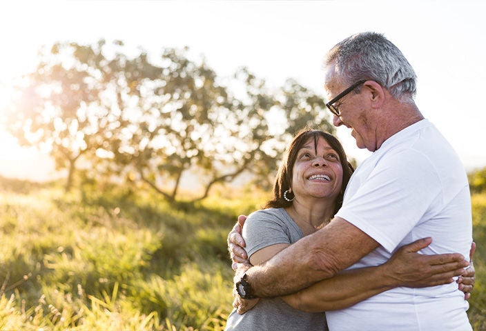 image of old couple holding and smiling while looking each other.