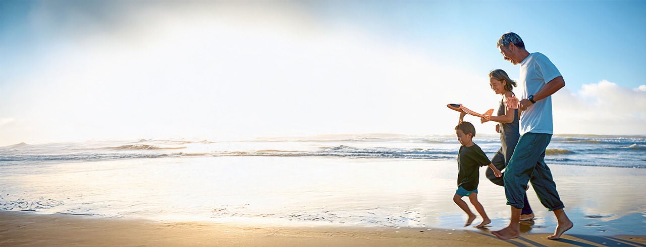 Family of three member running on beach and enjoying