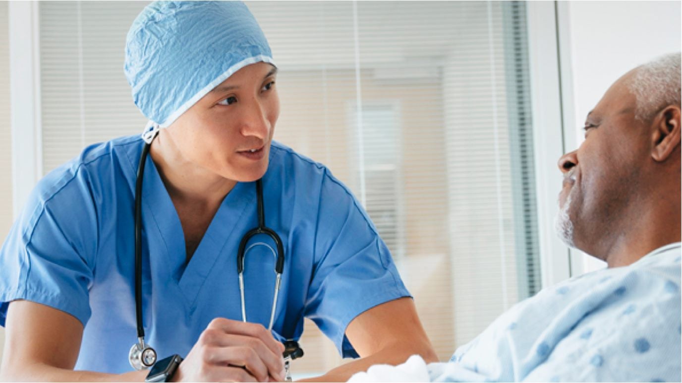 man speaking with his doctor in a hospital bed