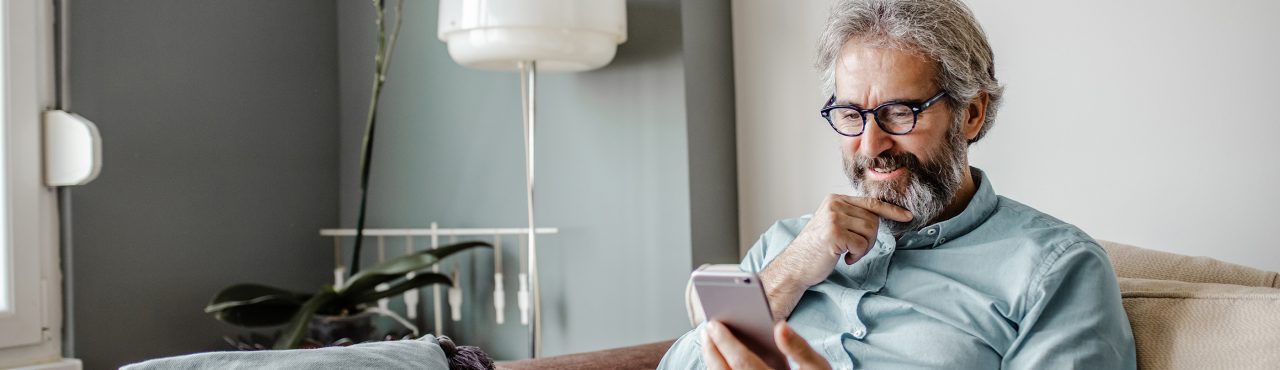 man in his home viewing a smartphone